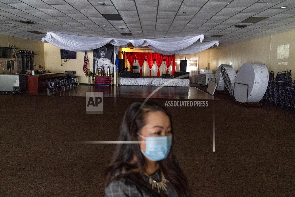 David Goldman Businesswoman and city councilor, Maiyoua Thao, 43, stands in the virus-shuttered banquet hall that serves the area's 5,000 Hmong immigrants, Aug. 19, 2020, in Appleton, Wis. Thao, a Hmong refugee from Laos, was initially drawn to the President Donald Trump mythology. She read his books and stayed in his hotel. But his administration has irked her by slashing the admission of refugees this year. She refuses to weigh in on national politics, saying that doing so could alienate the residents she serves. "I just want to see us Americans continue to be powerful and to be the heroes to the world." (AP Photo/David Goldman)