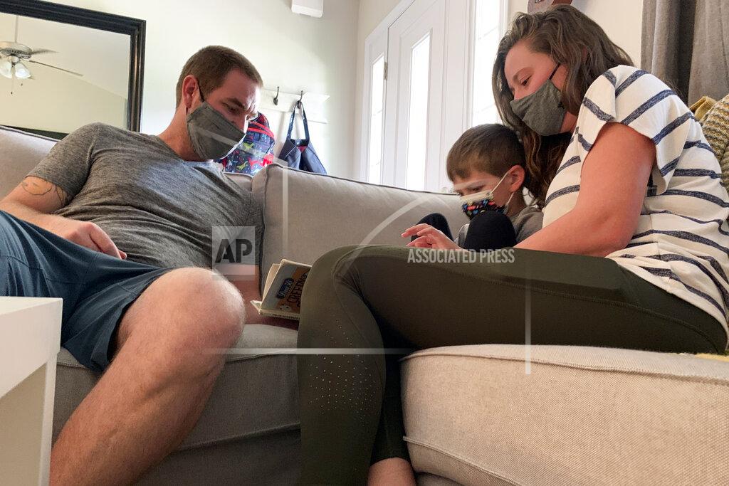 Sarah Blake Morgan Jeff and Emily Goss read with their five-year-old son on Monday, September 13th, 2021 inside their Monroe, N.C. home. After a year of strict quarantining, the Goss' were eager for Berkeley to begin in-person learning in the Union County School District. But after board members chose not to require children to wear masks and eliminate contact tracing procedures, the Goss' decided to homeschool Berkeley. (AP Photo/Sarah Blake Morgan)