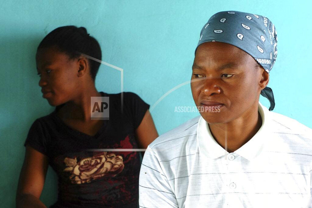 Neo Ntsoma Matefo Litali, 53, a Lesotho garment worker, and her 20-year-old daughter, Refiloe, sit together in their shared room in the town of Ha Thetsane, Maseru, Lesotho, on Friday, Dec. 11, 2020. At the beginning of the pandemic in March, Matefo was one of thousands garment workers around the world affected by the sudden closing of factories such as Tzicc Clothing, which makes apparel for U.S-based giants J.C. Penney and Walmart. Not only did the impact of the layoffs affect her finances but also took a great toll on her mental health. (Neo Ntsoma/The Fuller Project via AP)