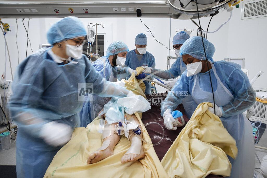 Lewis Joly Nurse Nadia Boudra, left, Doctor Alexy Tran Dinh, center, and nurse Yvana Faro, right, care for a patient inside an operating room transformed as a room for COVID-19 unconscious patients at Bichat Hospital, AP-HP, in Paris, Thursday, April 22, 2021. France still had nearly 6,000 critically ill patients in ICUs this week as the government embarked on the perilous process of gingerly easing the country out of its latest lockdown, too prematurely for those on pandemic frontlines in hospitals. President Emmanuel Macron's decision to reopen elementary schools on Monday and allow people to move about more freely again in May, even though ICU numbers have remained stubbornly higher than at any point since the pandemic's catastrophic first wave, marks another shift in multiple European capitals away from prioritizing hospitals. In France, Greece and elsewhere, the cursor is moving back toward other economic, social and educational imperatives. (AP Photo/Lewis Joly)
