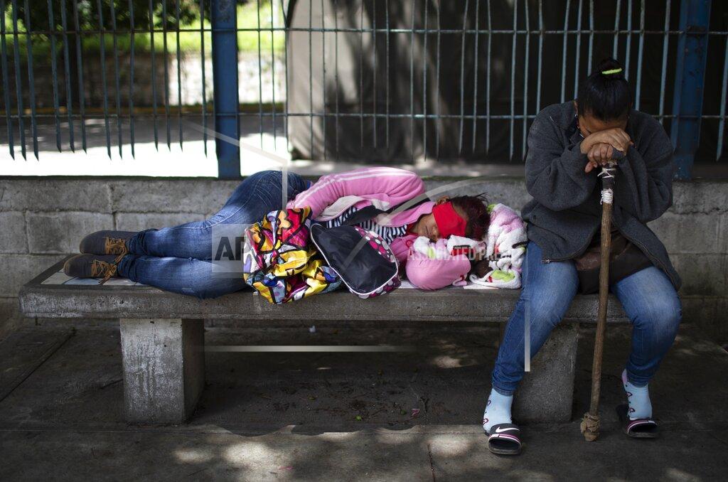 Ariana Cubillos Relatives of COVID-19 patients wait outside the COVID-19 wing of the José Gregorio Hernández Hospital in the Catia neighborhood of Caracas, Venezuela, Sunday, Oct 4, 2020. Throughout the day, relatives deliver food and security guards posted at a desk on the street take it inside to patients, while relatives of the weakest patients dress in protective gear to care for them. (AP Photo/Ariana Cubillos)