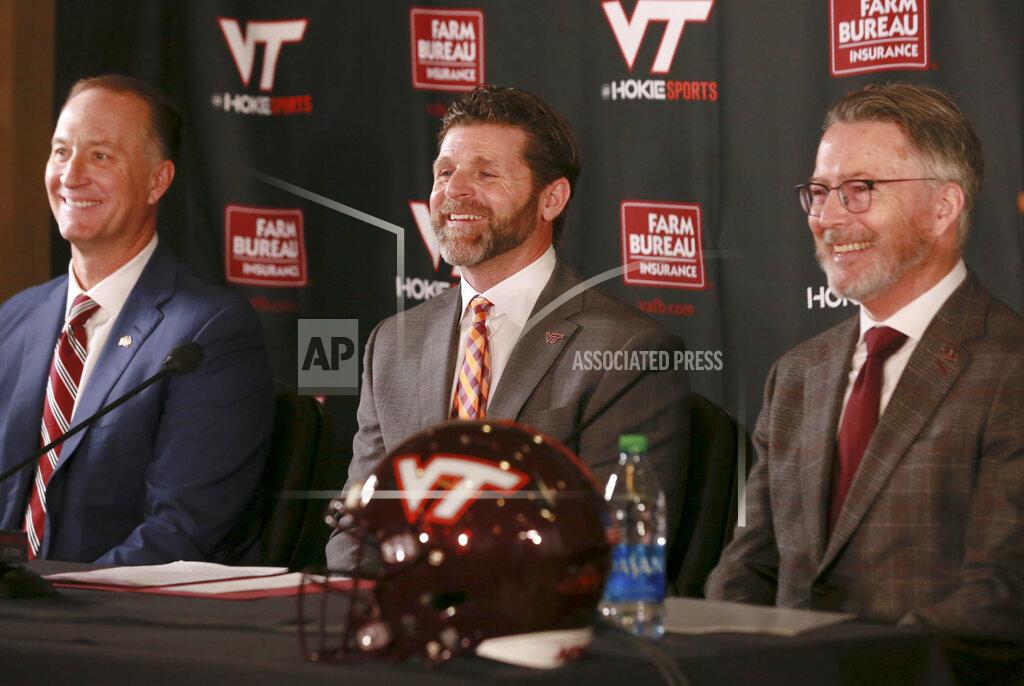 Matt Gentry New Virginia Tech NCAA college football head coach Brent Pry, center, poses with Virginia Tech Athletic Director Whit Babcock, left, and Virginia Tech President Tim Sands during an introductory press conference in Blacksburg Va., Thursday Dec. 2 2021. (Matt Gentry/The Roanoke Times via AP)