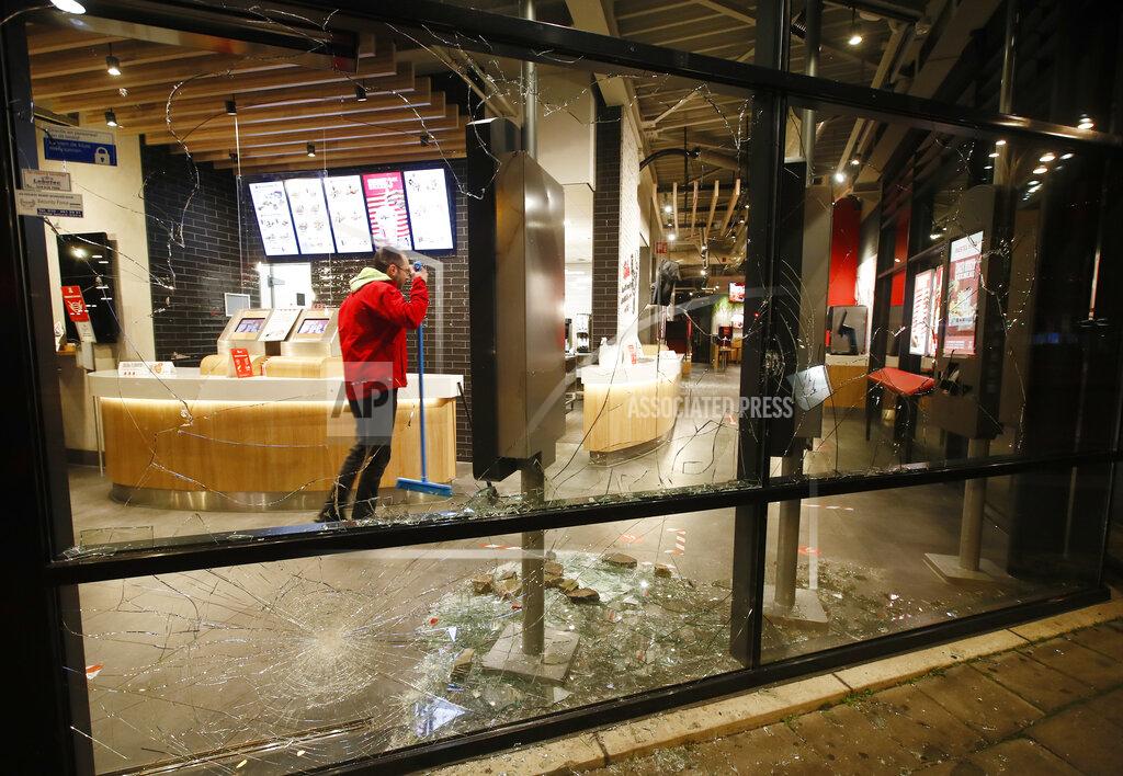 Peter Dejong A man cleans up broken glass from the smashed windows in a fast-food restaurant that was damaged in protests against a nation-wide curfew in Rotterdam, Netherlands, Monday, Jan. 25, 2021. The Netherlands Saturday entered its toughest phase of anti-coronavirus restrictions to date, imposing a nationwide night-time curfew from 9 p.m. until 4:30 a.m. in a bid to control the COVID-19 infection rate. (AP Photo/Peter Dejong)