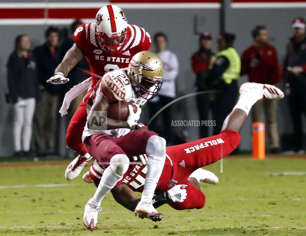 Chris Seward North Carolina State's Maurice Trowell (8) and Isaiah Moore (41) tackle Florida State's D.J. Matthews (29) during the second half of an NCAA college football game in Raleigh, N.C., Saturday, Nov. 3, 2018. (AP Photo/Chris Seward)