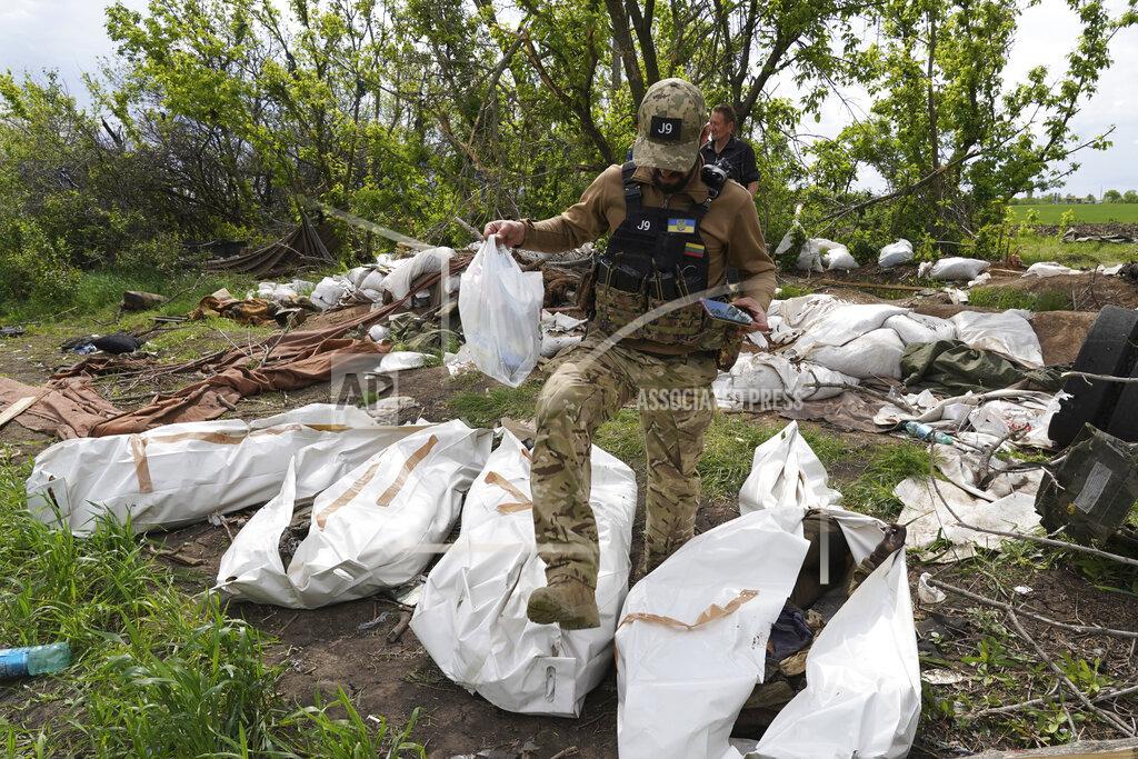 Andrii Marienko A Ukrainian serviceman works during the exhumation of killed Russian soldiers' at their former positions near the village of Malaya Rohan, on the outskirts of Kharkiv, Wednesday May 18, 2022. (AP Photo/Andrii Marienko)