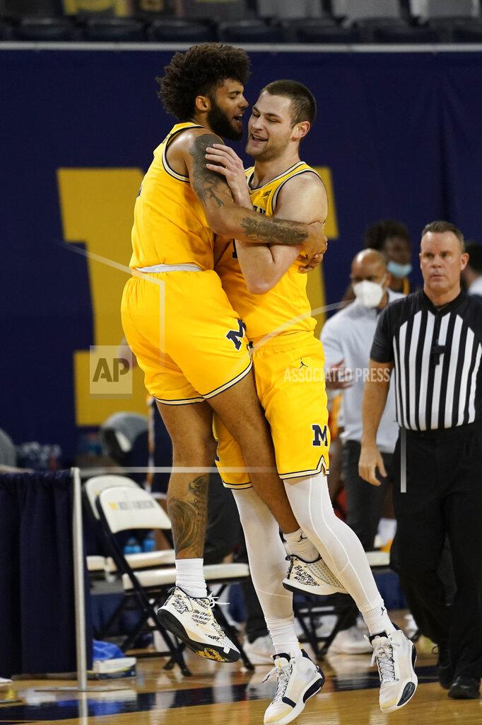 Paul Sancya Michigan forward Isaiah Livers, left, and Michigan center Hunter Dickinson celebrate in the first half of an NCAA college basketball game against Toledo in Ann Arbor, Mich., Wednesday, Dec. 9, 2020. (AP Photo/Paul Sancya)