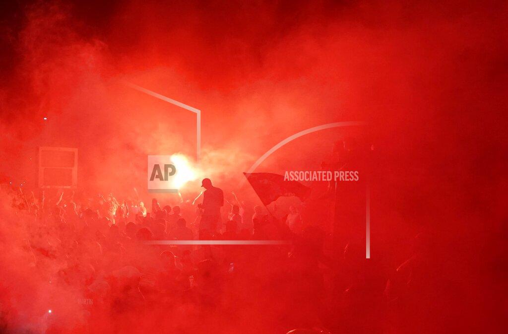 Jon Super Liverpool supporters celebrate as they gather outside of Anfield Stadium in Liverpool, England, Thursday, June 25, 2020 after Liverpool clinched the English Premier League title. Liverpool took the title after Manchester City failed to beat Chelsea on Wednesday evening. (AP photo/Jon Super)