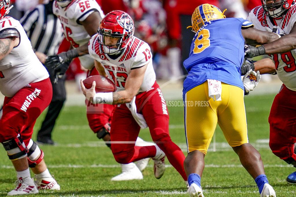 Keith Srakocic North Carolina State quarterback Devin Leary (13) scrambles for a first down past Pittsburgh defensive lineman Calijah Kancey (8) during the second half of an NCAA college football game, Saturday, Oct. 3, 2020, in Pittsburgh. North Carolina State won 30-29. (AP Photo/Keith Srakocic)