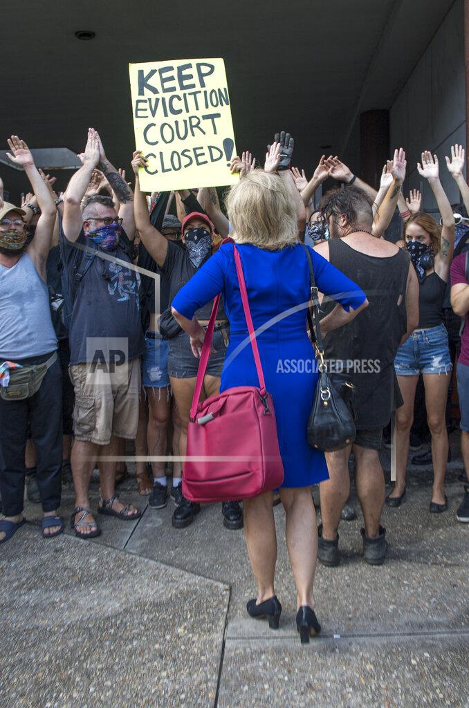 Chris Granger A woman trying to enter the courthouse is prevented from entering by New Orleans Renters Rights Assembly protesters who blocked an entrance to First City Court near New Orleans City Hall on Thursday, July 30, 2020. (Chris Granger/The Advocate via AP)