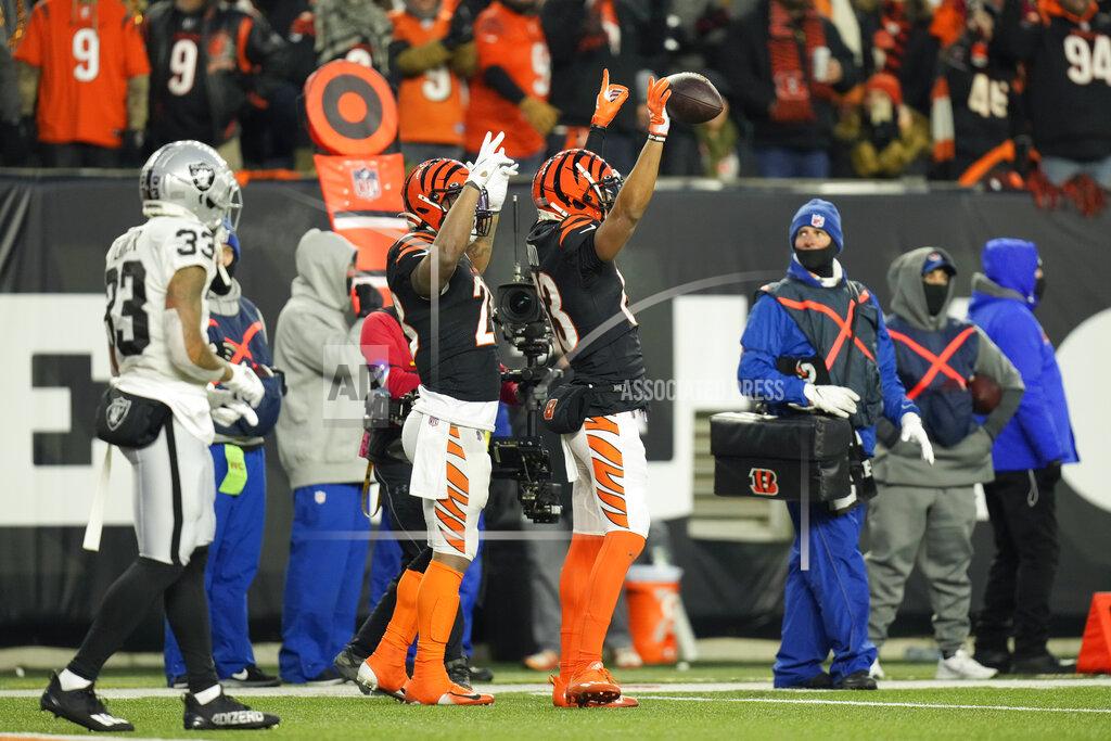 Aj Mast Cincinnati Bengals' Tyler Boyd (83) and Joe Mixon (28) signal a touchdown in front of Las Vegas Raiders' Roderic Teamer (33) during the first half of an NFL wild-card playoff football game, Saturday, Jan. 15, 2022, in Cincinnati. Boyd made the touchdown reception. (AP Photo/AJ Mast)