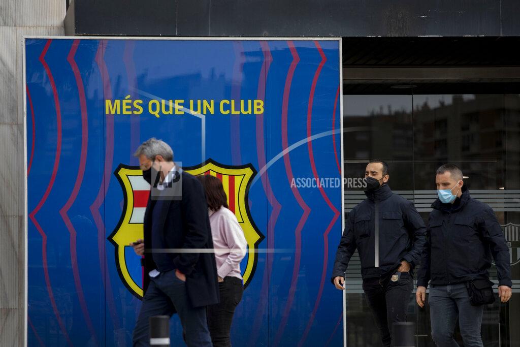 Joan Monfort FILE - In this file photo dated Monday March 1, 2021, Catalan police walk outside FC Barcelona's offices in Barcelona, Spain, with club sign reading "more than a club". Over 110,000 Barcelona club members will elect a new president Sunday March 7, 2021, amidst a club crisis with police investigation and a debt burden. (AP Photo/Joan Monfort, FILE)