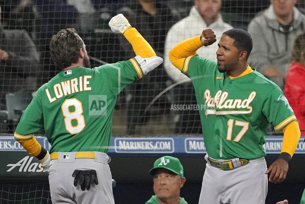 Ted S. Warren Oakland Athletics' Jed Lowrie (8) is greeted at the dugout by Elvis Andrus (17), after Lowrie hit a two-run home run during the fifth inning of a baseball game against the Seattle Mariners, Tuesday, May 24, 2022, in Seattle. Andrus hit a solo home run during the sixth inning. (AP Photo/Ted S. Warren)