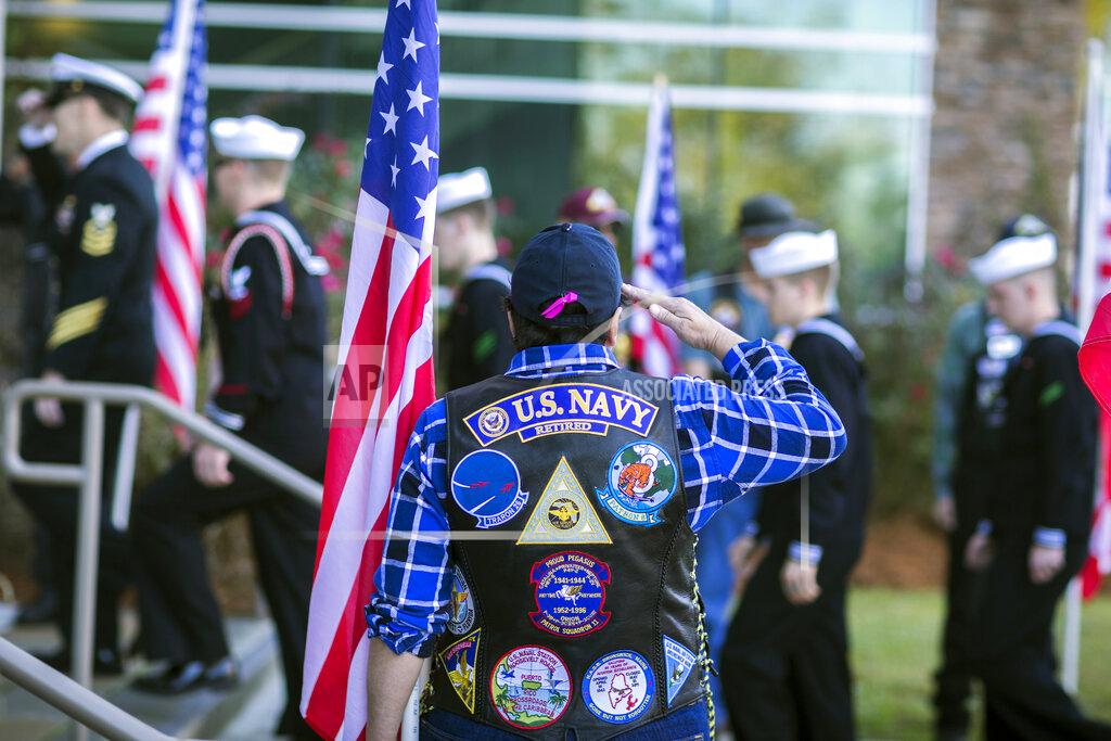 Stephen B. Morton FILE - In this Dec. 16, 2019 file photo, Fran Bitter, a volunteer with the Patriot Guard Riders of Georgia, salutes a group of sailors as they enter a funeral service for U.S. Navy Airmen Apprentice Cameron Walters at the Compassion Christian Church in Savannah, Ga. Walters was one of three Navy sailors killed in a Saudi gunman's attack at Naval Air Station Pensacola in Florida on Dec. 6. The FBI has found a link between the gunman in a deadly attack at a military base last December and an al-Qaida operative. That's according to a U.S. official who spoke to The Associated Press on Monday. (Stephen B. Morton/Atlanta Journal-Constitution via AP)