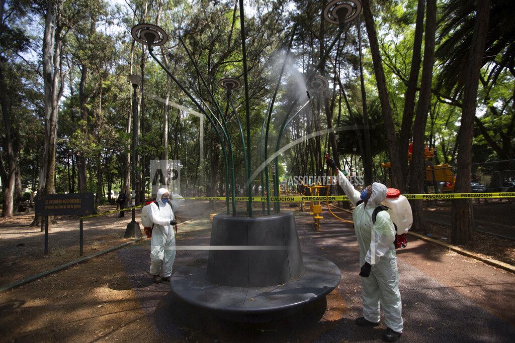 Fernando Llano Municipal employees, wearing protective gear, disinfect an area of a public park as a preventive measure against the spread of the new coronavirus, in Mexico City, Saturday, April 4, 2020. Mexico has started taking tougher measures against the new coronavirus, but some experts warn the country is acting too late and testing too little to prevent the type of crisis unfolding across the border in the United States. (AP Photo/Fernando Llano)