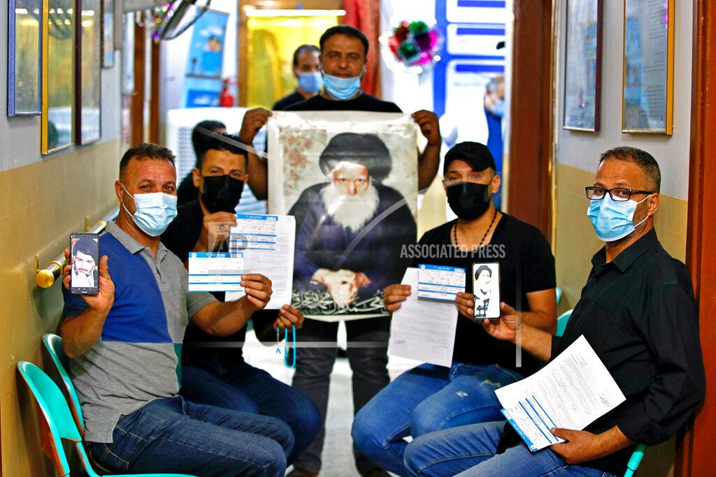 Hadi Mizban Followers of Shiite cleric Muqtada al-Sadr, pose for a photo holding pictures of him and his father and their vaccination cards as they wait to receive a Chinese Sinopharm vaccine at a clinic in Sadr City, Baghdad, Iraq, Wednesday, May 4, 2021. Iraq’s vaccine rollout had been faltering for weeks. Apathy, fear and rumors kept many from getting vaccinated despite a serious surge in coronavirus infections and calls by the government for people to register for shots. It took al-Sadr’s public endorsement of vaccinations — and images of him getting the shot — to turn things around. (AP Photo/Hadi Mizban)