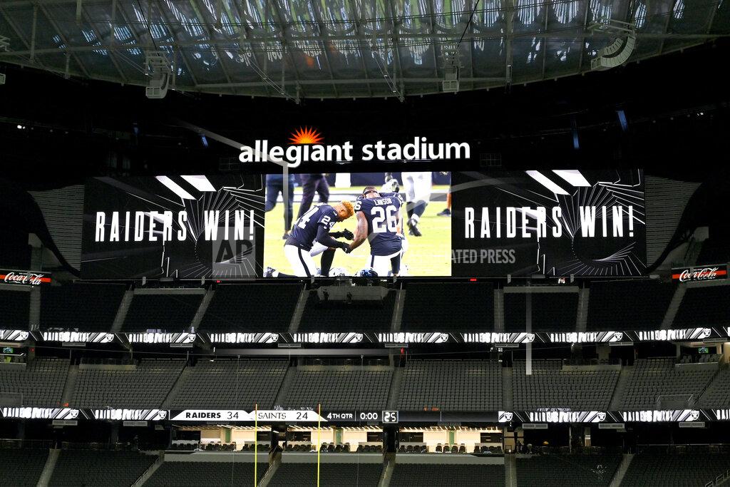 David Becker A screen shows Las Vegas Raiders players kneeling after defeating the New Orleans Saints in an NFL football game, Monday, Sept. 21, 2020, in Las Vegas. (AP Photo/David Becker)
