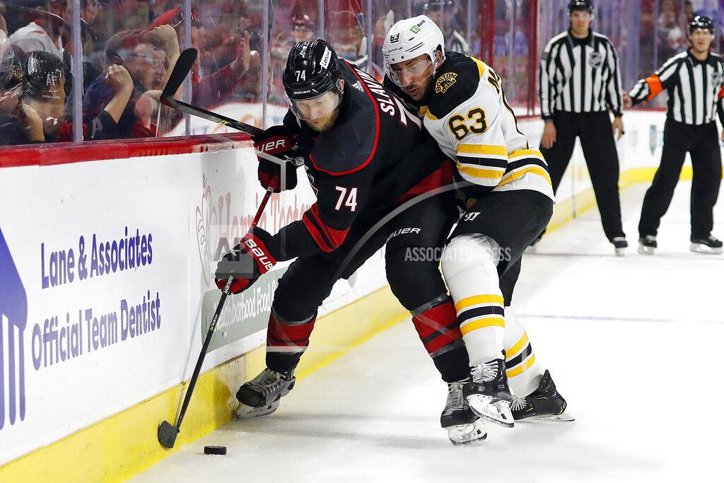 Karl B Deblaker Carolina Hurricanes' Jaccob Slavin (74) battles for the puck during with Boston Bruins' Brad Marchand (63) the first period of Game 7 of an NHL hockey Stanley Cup first-round playoff series in Raleigh, N.C., Saturday, May 14, 2022. (AP Photo/Karl B DeBlaker)