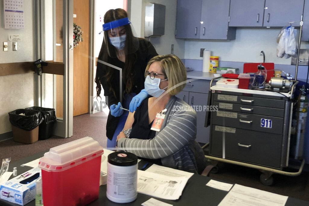 Mead Gruver Cheyenne-Laramie County Health Department nurse Valencia Bautista, left, administers Wyoming's first shot of the Pfizer-BioNTech COVID-19 vaccine to Terry Thayn, who is also a nurse for the department, on Tuesday, Dec. 15, 2020, in Cheyenne, Wyo. (AP Photo/Mead Gruver)