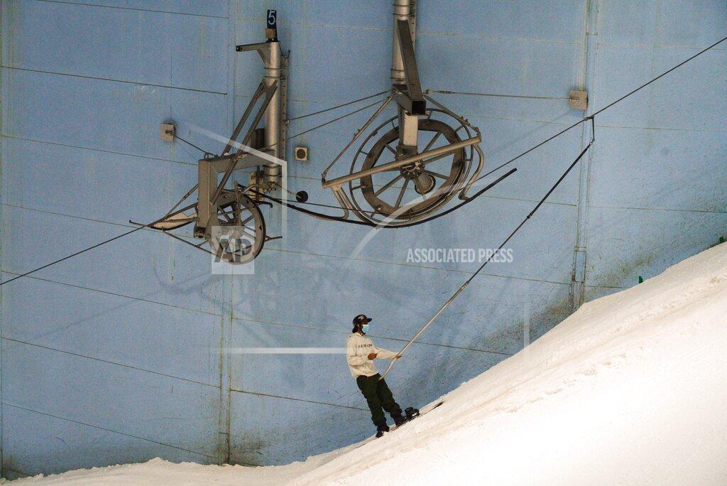 Jon Gambrell A snowboarder heads up the hill at Ski Dubai in Mall of the Emirates in Dubai, United Arab Emirates, Wednesday, May 27, 2020. Dubai on Wednesday loosed its restrictions imposed over the coronavirus pandemic, allowing movie theaters and other attractions to operate. (AP Photo/Jon Gambrell)