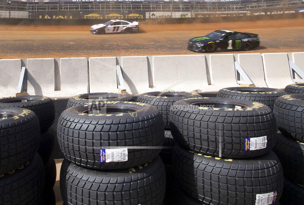 David Crigger With the new Goodyear Eagle dirt tires stacked along the infield wall, Denny Hamlin and Kurt Busch drive on the dirt track during NASCAR Cup Series practice, Friday, March 26, 2021, at Bristol Motor Speedway in Bristol, Tenn. (David Crigger/Bristol Herald Courier via AP)