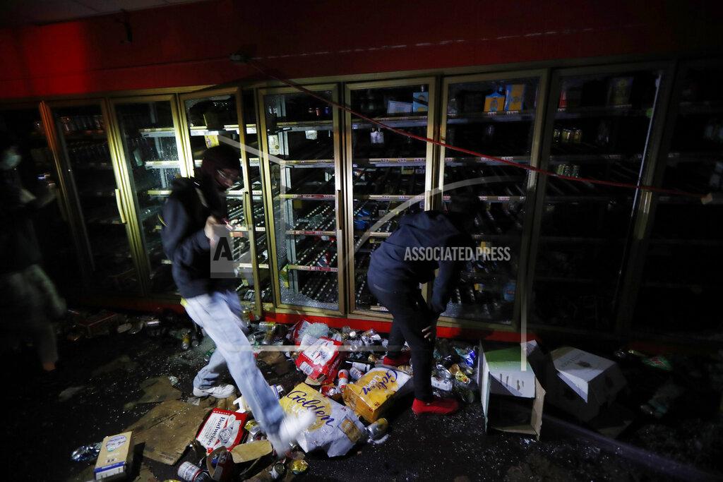 John Minchillo People take items from a liquor store Thursday, May 28, 2020, in Minneapolis. Protests over the death of George Floyd, a black man who died in police custody Monday, broke out in Minneapolis for a third straight night. (AP Photo/John Minchillo)