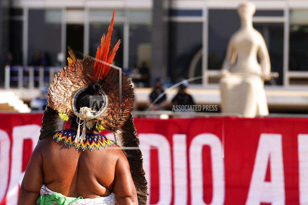 Eraldo Peres An Indigenous woman walks after the Supreme Court judges' decision to suspend the vote that defines the demarcation of indigenous lands, during a protest in front of the Supreme Court building, in Brasilia, Brazil, Wednesday, Sept. 15, 2021. (AP Photo/Eraldo Peres)