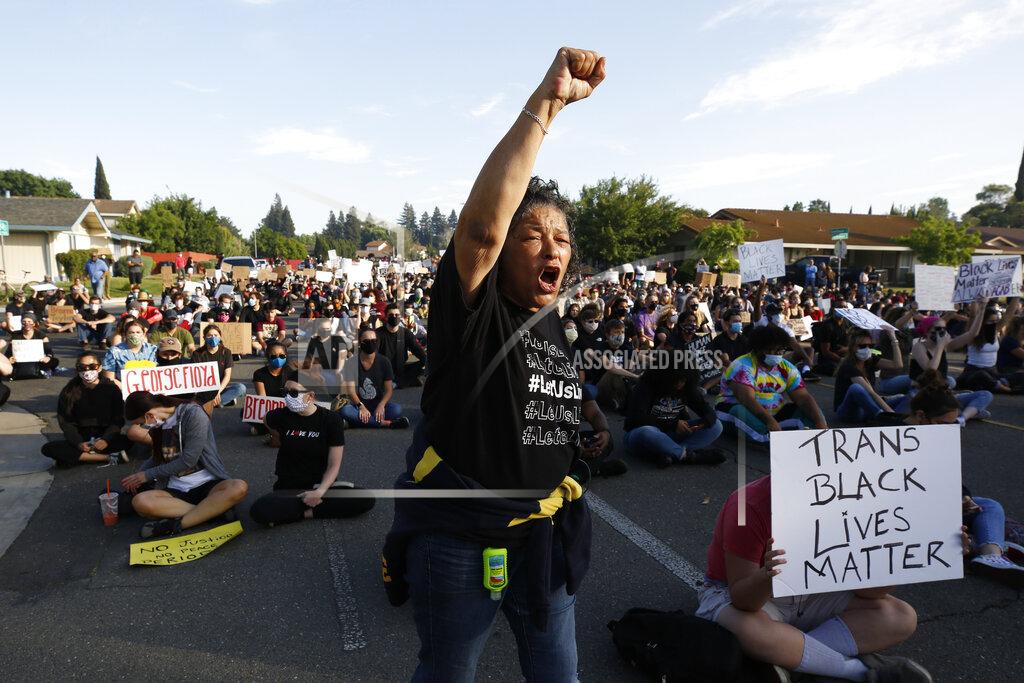 Rich Pedroncelli Allegra Taylor joins other protesters, Friday, June, 5, 2020, in shouting the name "George Floyd!" during a demonstration near the home of Sacramento Mayor Darrell Steinberg in Sacramento, Calif. Floyd, a black man, died after being restrained by Minneapolis police officers on May 25. (AP Photo/Rich Pedroncelli)