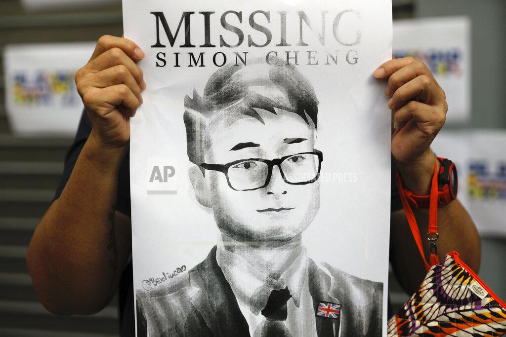FILE - In this Aug. 21, 2019, file photo, a supporter holds a poster outside of the British Consulate in Hong Kong during a rally in support of an employee of the consulate who was detained while returning from a trip to China. A former employee of the British Consulate in Hong Kong says he was detained and tortured by Chinese secret police trying to extract information about massive anti-government protests in the territory. (AP Photo/Vincent Yu, File)