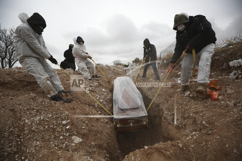 Christian Chavez FILE - In this Oct. 27, 2020 file photo, workers wearing full protection gear amid the new coronavirus pandemic, lower a coffin into a grave in an area of the San Rafael municipal cemetery set apart for people who have died from COVID-19, in Ciudad Juarez, Mexico. According to a report released the third week of April, by the University of California, San Francisco, Mexico would have had a significantly lower COVID-19 death toll if it had reacted as well as the average government. (AP Photo/Christian Chavez, File)