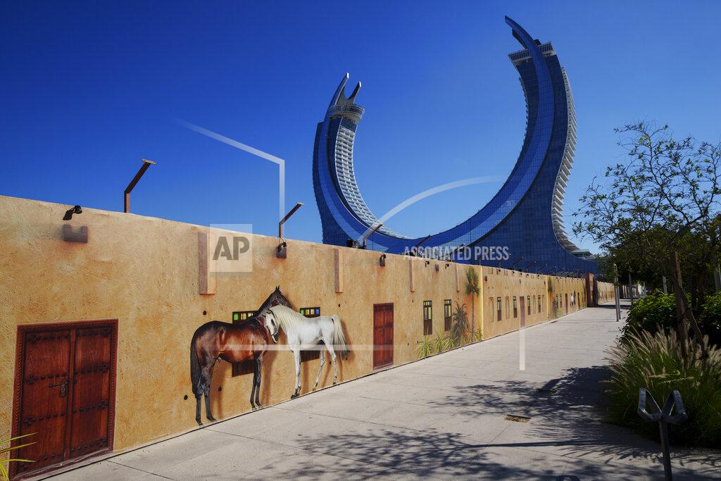 Pavel Golovkin Images of horses are seen on a fence of a construction cite with the Crescent Tower Lusail in the background in Lusail downtown, Qatar, Thursday, Nov. 24, 2022. (AP Photo/Pavel Golovkin)