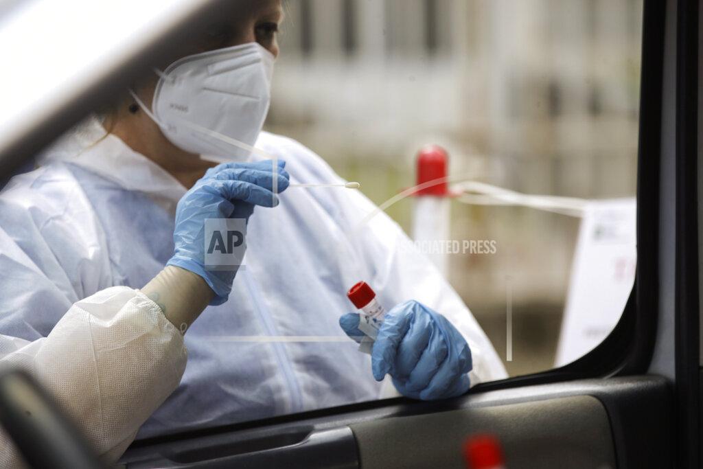 Luca Bruno A medical worker wearing protective gear takes swabs to test for COVID-19 at a drive-through for people returning from Croatia, Spain, Malta and Greece, at the San Carlo hospital, in Milan, Italy, Tuesday, Aug. 25, 2020. People returning to Italy from Spain, Malta, Greece and Croatia must be tested within 48 hours of entering the country, after those nations saw worrisome upticks in infections. (AP Photo/Luca Bruno)
