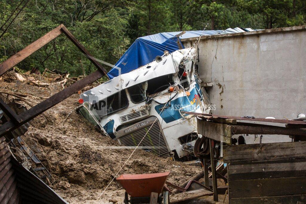 Esteban Biba A semi is partially buried in a massive, rain-fueled landslide in the village of Queja, in Guatemala, Saturday, Nov. 7, 2020, in the aftermath of Tropical Storm Eta. (Esteban Biba/Pool Photo via AP)