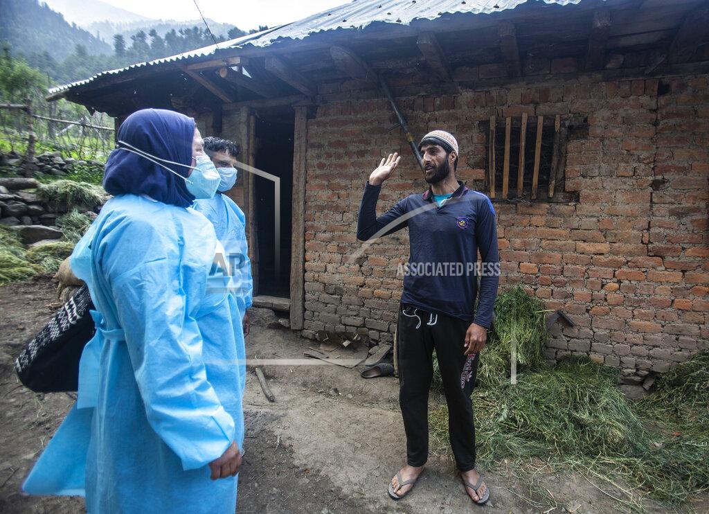 Mukhtar Khan Health workers talk to Bilal Chauhan, a local villager, to persuade him to take the COVID-19 vaccine in Minnar village, north of Srinagar, Indian controlled Kashmir, Thursday, June 10, 2021. Chauhan and many other villagers refused to take vaccine saying the were from the mountains and too hardy to be affected by the virus. (AP Photo/Mukhtar Khan)