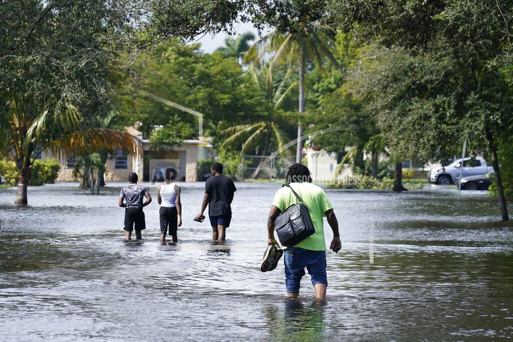 Marta Lavandier Residents walk a flooded street to reach their homes, Monday, Nov. 9, 2020 in Fort Lauderdale, Fla. Tropical Storm Eta caused severe flooding in South Florida in areas already saturated from previous downpours. (AP Photo/Marta Lavandier)