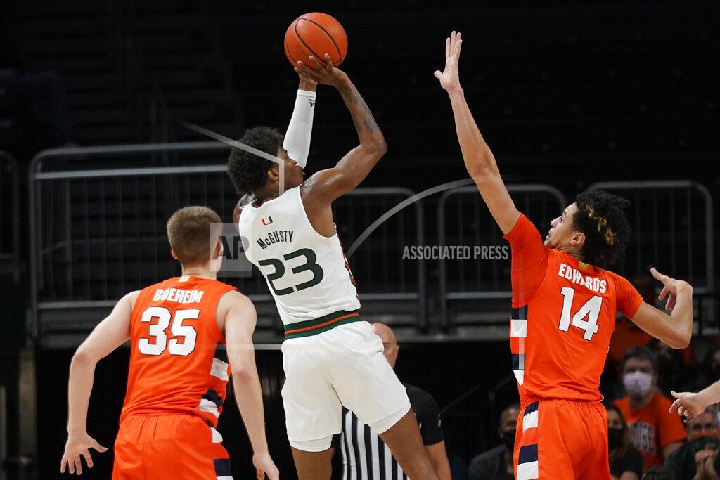 Wilfredo Lee Miami guard Kameron McGusty (23) takes a shot against Syracuse center Jesse Edwards (14) and guard Buddy Boeheim (35) during the first half of an NCAA college basketball game, Wednesday, Jan. 5, 2022, in Coral Gables, Fla. (AP Photo/Wilfredo Lee)