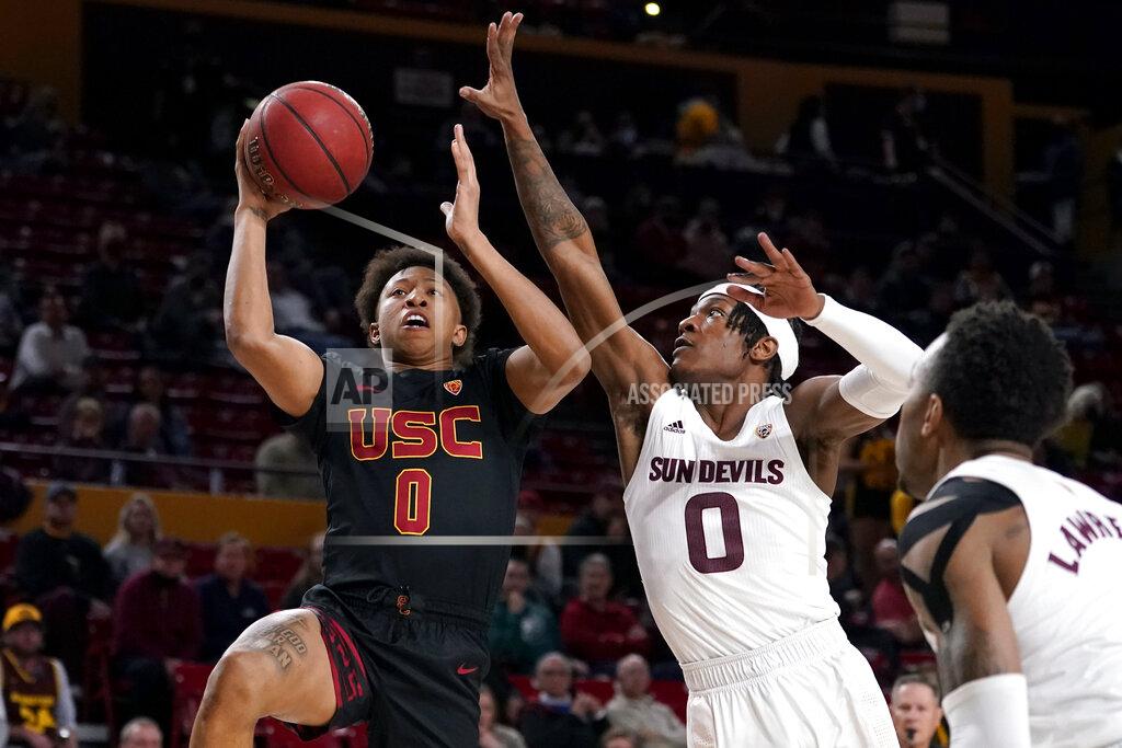 Matt York CORRECTS LOCATION TO TEMPE, INSTEAD OF PHOENIX - Southern California guard Boogie Ellis, left, shoots past Arizona State guard DJ Horne during the first half of an NCAA college basketball game, Thursday, Feb. 3, 2022, in Tempe, Ariz. (AP Photo/Matt York)