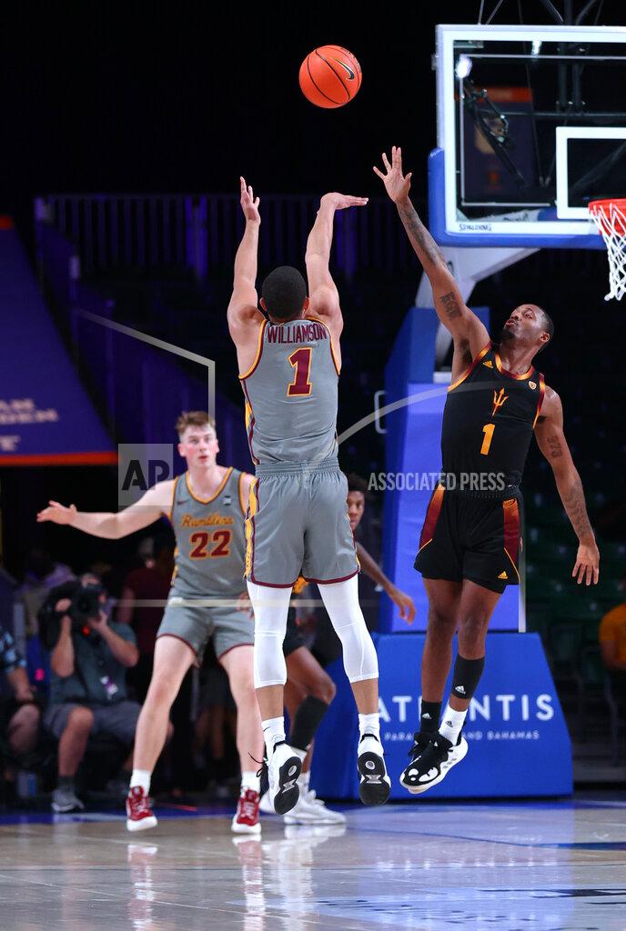Tim Aylen In a photo provided by Bahamas Visual Services, Loyola Chicago guard Lucas Williamson (1) shoots against Arizona State's Luther Muhammad during an NCAA college basketball game at Paradise Island, Bahamas, Friday, Nov. 26, 2021. (Tim Aylen/Bahamas Visual Services via AP)