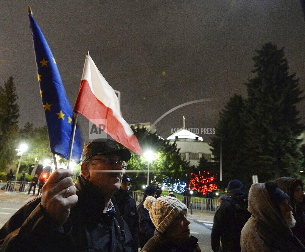 Czarek Sokolowski FILE - In this Jan. 23, 2020, file photo, a man holding a Poland and European Union flags take part in a protest outside Poland's parliament building in Warsaw, Poland. The European Union still hasn't completely sorted out its messy post-divorce relationship with Britain — but it has already been plunged into another major crisis. This time the 27-member union is being tested as Poland and Hungary block passage of its budget for the next seven years and an ambitious package aimed at rescuing economies ravaged by the coronavirus pandemic. (AP Photo/Czarek Sokolowski, File)
