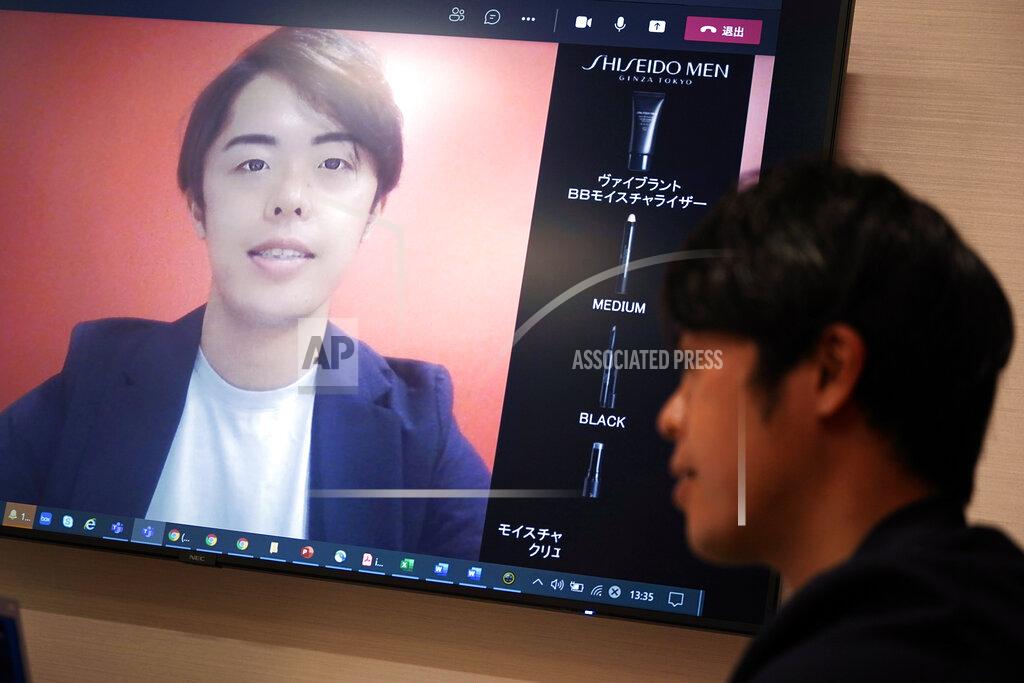 Eugene Hoshiko Naruhiko Ito, assistant brand manager of Brand Shiseido Group, demonstrates Shiseido released AR makeup filter for men to use for online meetings in Tokyo Thursday, April 15, 2021. A large personal care company, Shiseido, says one of its male makeup lines has seen double-digit growth during the coronavirus pandemic. Company officials give a similar reason: Men, confronted with the sight of their faces repeatedly during online meetings, want to improve what they see. (AP Photo/Eugene Hoshiko)