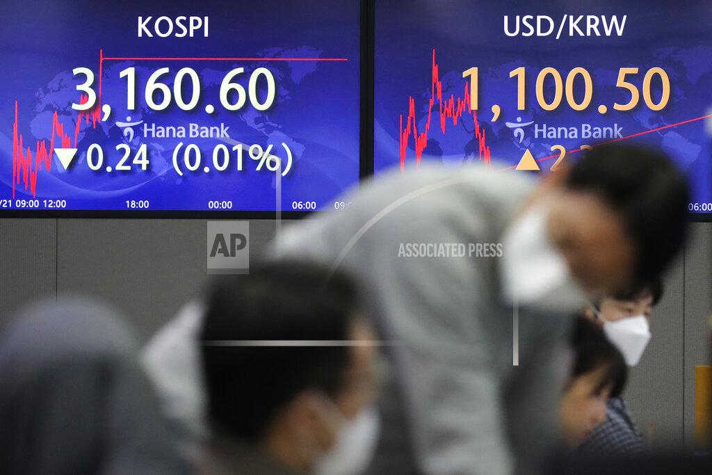 Lee Jin-Man Currency traders talk near the screens showing the Korea Composite Stock Price Index (KOSPI), left, and the foreign exchange rate between U.S. dollar and South Korean won at the foreign exchange dealing room in Seoul, South Korea, Friday, Jan. 22, 2021. Asian stock markets retreated Friday after a resurgence of coronavirus infections in China and a rise in cases in Southeast Asia.(AP Photo/Lee Jin-man)
