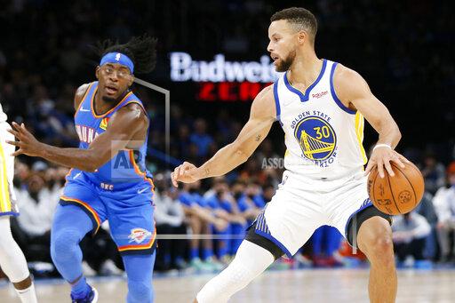 Golden State Warriors guard Stephen Curry (30) dribbles near Oklahoma City Thunder forward Luguentz Dort, left, in the first half of an NBA basketball game Tuesday, Oct. 26, 2021, in Oklahoma City. (AP Photo/Nate Billings)