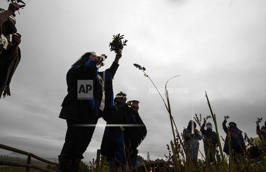 Esteban Felix Mapuche Indigenous people take part in a ritual during a total solar eclipse in Carahue, La Araucania, Chile, Monday, Dec. 14, 2020. The total eclipse was visible from Chile and the northern Patagonia region of Argentina, and as a partial solar eclipse in Bolivia, Brazil, Ecuador, Paraguay, Peru and Uruguay. (AP Photo/Esteban Felix)