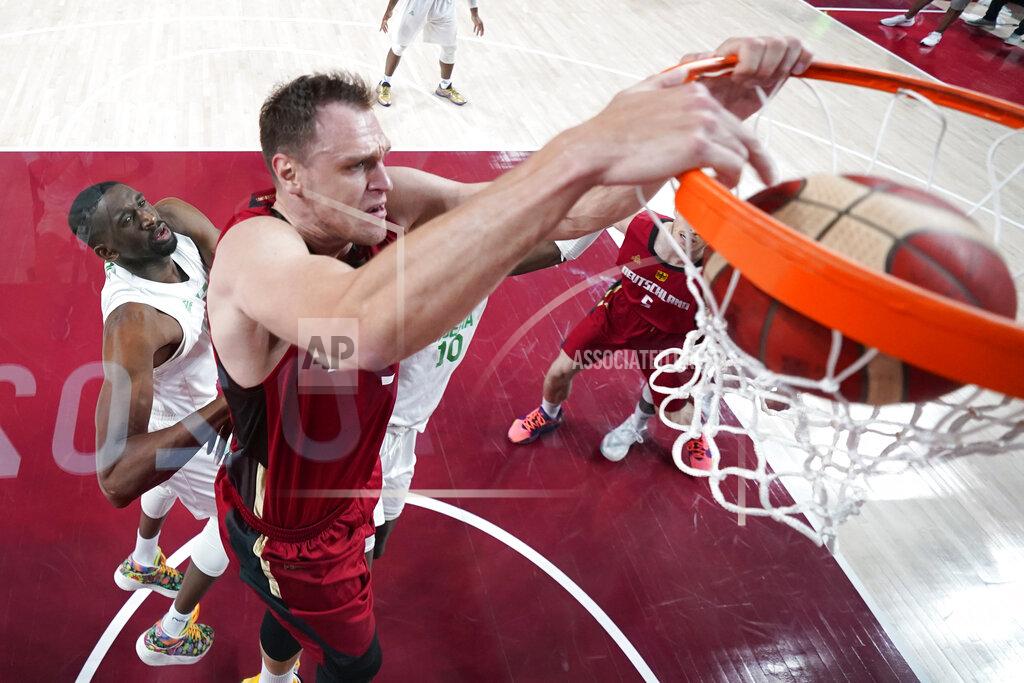 Charlie Neibergall Germany's Johannes Voigtmann dunks the ball ahead of Nigeria's Ekpe Udoh, left, during a men's basketball preliminary round game at the 2020 Summer Olympics, Wednesday, July 28, 2021, in Saitama, Japan. (Charlie Neibergall/Pool Photo via AP)