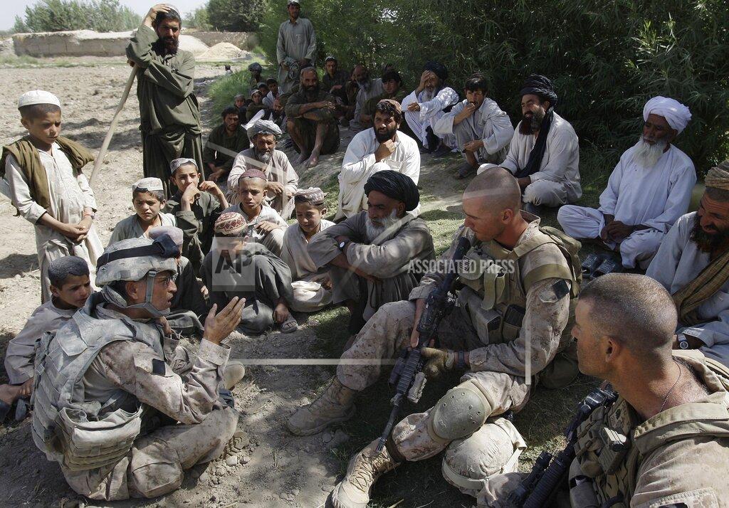 David Guttenfelder FILE - This July 2, 2009, photo shows Josh Habib, far left, a 53-year-old translator for the U.S. Marines, speaking with Afghan villagers and two Marines in the Nawa district of Afghanistan's Helmand province. More than 200 Afghans were due to land Friday, July 30, 2021 in the United States in the first of several planned evacuation flights for former translators and others as the U.S. ends its nearly 20-year war in Afghanistan. (AP Photo/David Guttenfelder)