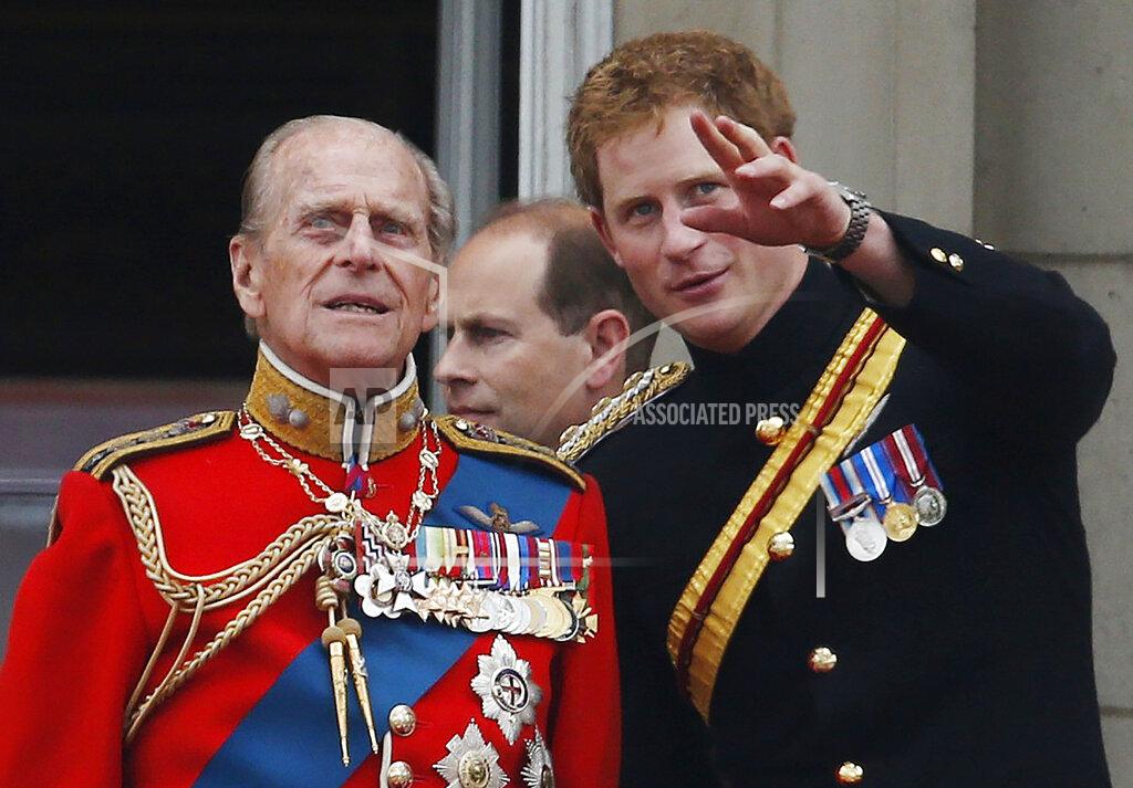 Lefteris Pitarakis FILE - In this June 14, 2014 file photo, Britain's Prince Harry talks to Prince Philip, left, as members of the Royal family appear on the balcony of Buckingham Palace, during the Trooping The Colour parade, in central London. In the TV program ‘Prince Philip: The Royal Family Remembers’ released late Saturday Sept. 18, 2021, members of the royal family spoke admiringly of the late Duke of Edinburgh’s barbecuing skills and Prince Harry described how his grandfather would “never probe” but listen intently about his two tour of duties to Helmand province during the war in Afghanistan. (AP Photo/Lefteris Pitarakis, File)