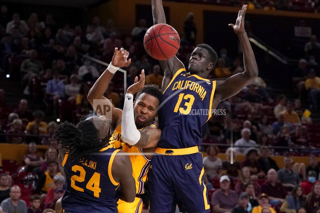 Matt York Arizona State forward Kimani Lawrence passes between California forward Kuany Kuany (13) and forward Sam Alajiki (24) during the second half of an NCAA college basketball game, Thursday, March 3, 2022, in Tempe, Ariz. (AP Photo/Matt York)
