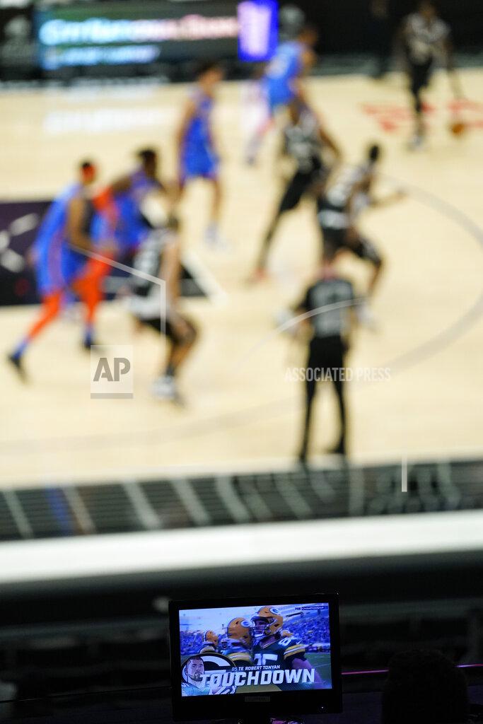Ashley Landis The Green Bay Packers are seen celebrating a touchdown on the television broadcast during their NFL conference championship game while the Oklahoma City Thunder take on the Los Angeles Clippers during the second quarter of an NBA basketball game Sunday, Jan. 24, 2021, in Los Angeles. (AP Photo/Ashley Landis)