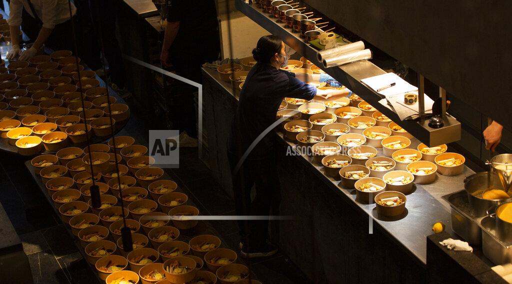 Virginia Mayo A staff member works on a dish as she helps to prepare part of nearly 600 take-away orders at Sergio Herman's Le Pristine restaurant in Antwerp, Belgium, Saturday, Nov. 7, 2020. Of all the many challenges the pandemic throws up for all kinds of professions, this one has been particularly tough: How to put a three-star chef into a takeout box. (AP Photo/Virginia Mayo)