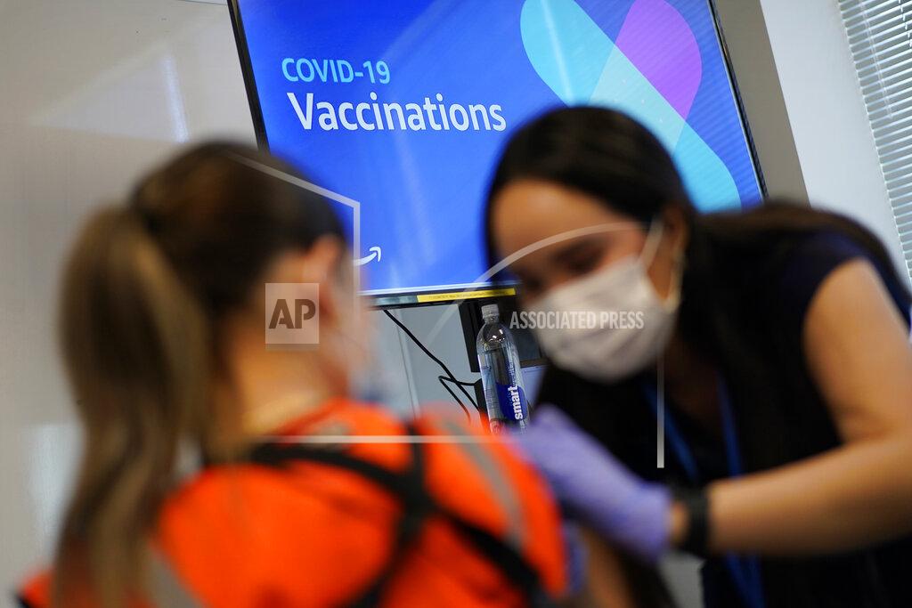 John Locher Registered nurse Sofia Mercado, right, administers a vaccine shot at a vaccination event for workers at an Amazon Fulfillment Center, Wednesday, March 31, 2021, in North Las Vegas, Nev. A growing number of companies and labor unions are directly securing coronavirus vaccines for their workers. Amazon and some other large companies have hosted on-site inoculations, while smaller operations have helped book appointments for their workers. (AP Photo/John Locher)