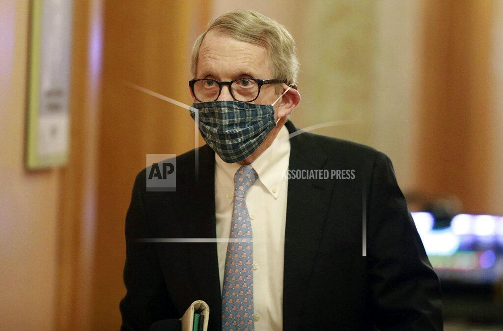 Wearing his protective mask made by his wife, Ohio Gov. Mike DeWine walks into his daily coronavirus news conference on Thursday, April 16, 2020, at the Ohio Statehouse in Columbus, Ohio. (Doral Chenoweth/The Columbus Dispatch via AP)